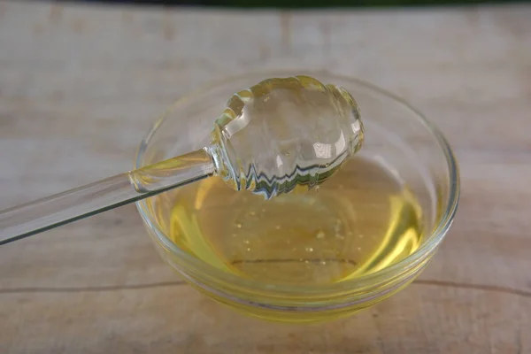 Honig. Flüssiger Honig im Glas mit Dipper.Glasstab für Honig in einer Glasschale auf einem Holztisch. Frischer Honig — Stockfoto