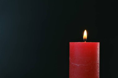 Mum arka planda. Siyah arka planda yanan kırmızı mum. mum alevi.