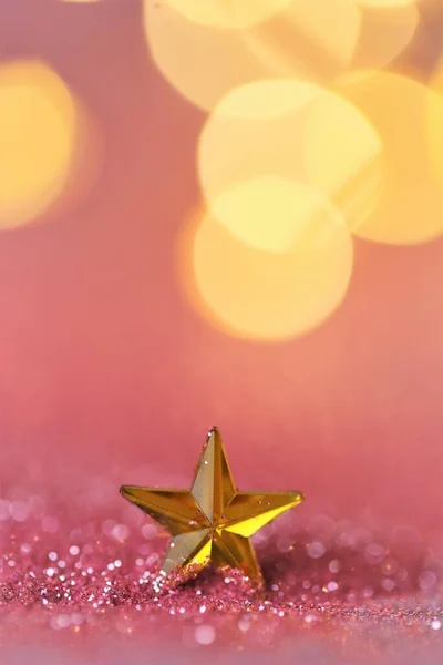 Ano Novo e fundo de Natal. estrela de ouro em brilho rosa no fundo bokeh dourado brilhante.Fundo festivo bonito em tons de ouro rosa.Textura brilhante — Fotografia de Stock