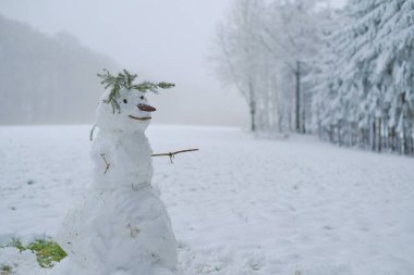 Karlı bir kış ormanında kardan adam. Noel ve yeni yıl festivali. Kış oyunları ve eğlence.