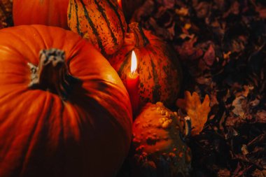 Pumpkins and Candles for Autumn Celebration.Dark atmosphere with pumpkins and candles.