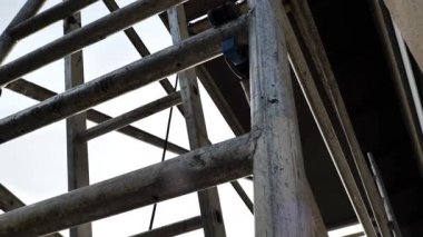 Tamir ve inşaat için metal iskeleler. Ekipman ve inşaat aletleri. Ev inşaatı ve yenileme konsepti. İskeledeki evin temel ve duvarları. 4k görüntü