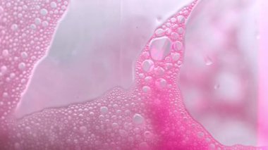 Pembe sabun köpükleri arka planda. Köpüklü sabun köpüğü dokusu. Pembe köpük makro arka plan. 4k görüntü