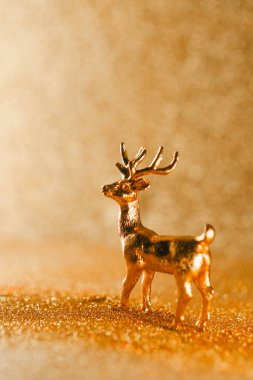 altın geyik heykelciği altın bir bokeh ile çevrili pırıl pırıl bir arka planda. Altın tonlarda Noel duvar kağıdı.. 