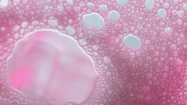 Pembe Kozmetik desenli makro. Pembe köpük köpükleri aşağı akıyor. Temizlik ve hijyen arka planı. Köpüklü sabun köpüğü. Doku köpüğü. 