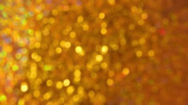 Altın parıltılar ve parıltılı arka plan. Parlak altın yeni yıl ve Noel duvar kâğıdı. 4k görüntü