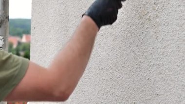 Duvar boyası. Boyalı silindirli bir adam duvar bejini boyuyor. 4k görüntü