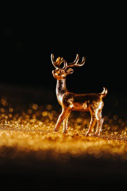 Altın Geyikli Noel arkaplanı. Altın parıltılı altın geyik ve siyah arka planda altın çukur. Noel sembollü şenlikli atmosfer..