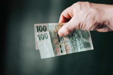 Çek Koruna banknotları parmaklarının arasında duruyor. Nakit işleme, tüketici harcamaları, tasarruf ve günlük para yönetimi kavramı. gerçekçi finansal yaşam tarzı sahnesi.
