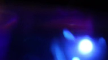 Yumuşak bulanıklık ve yansımalarla karanlık bir ortamda dinamik neon ışığı hareketi. Enerji, hız, gece atmosferi ve gelecekteki dijital estetiği aktaran soyut parlayan arkaplan