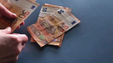 Avrupa Birliği 'nde Kadın Kazancı. Gri mavi arka planda euro banknotlarını sayan kadın elleri. 4k görüntü