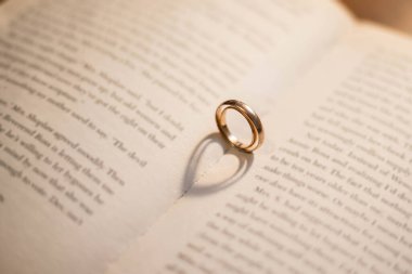 Açık sayfasında kalp gölgesi olan İncil 'deki iki alyans. Nişan, düğün ve nikah. Evlilikten. Bir aşk yemini..