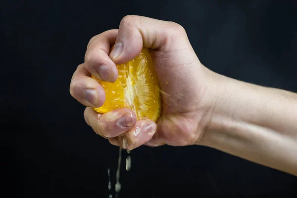 Man Hand Holds Orange Clenches His Fist Squeezing Juice Black — Stock Photo, Image