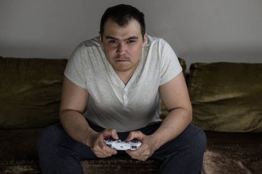 Bir adam video oyunu konsolunda oynuyor ve kaybettiği için kızgın. Canı sıkkın bir adam bir video oyununda kaybeder..