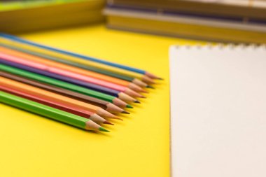 Boş bir kağıt ve renkli kalemler. Okul için ofis malzemeleri..