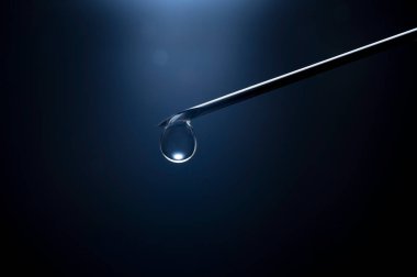 Kanüllü bir şırıngayı yakın çekim yap ve koyu mavi arkaplanın önüne bırak.