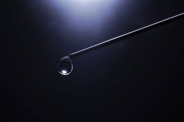 Kanüllü bir şırıngayı yakın çekim yap ve koyu mavi arkaplanın önüne bırak.