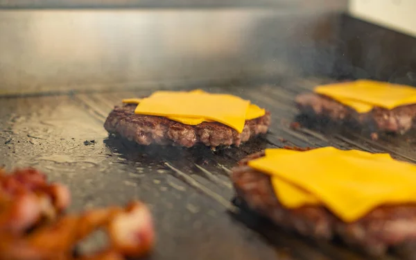 Izgara lokantasında hamburger yap. Akşam güneşinde gaz ızgarasında pişen hamburgerler.