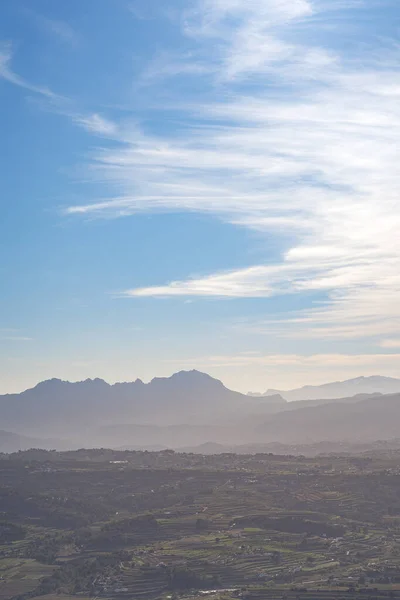 Açık bir günde köyler arası dağ, az bulutla, arka planda deniz. Alicante, İspanya 'da.
