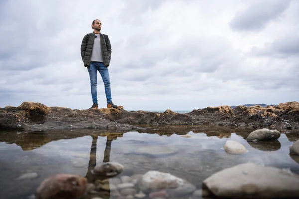 Hombre Refleja Charco Mar Día Nublado Lleva Una Chaqueta Verde — Foto de Stock