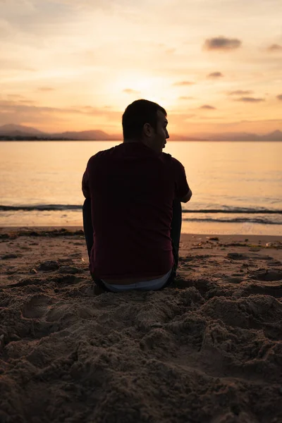 Hombre Sentado Orilla Del Mar Mirando Puesta Sol Está Sentado — Foto de Stock