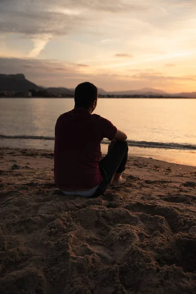 Hombre Sentado Orilla Del Mar Mirando Puesta Sol Está Sentado — Foto de Stock