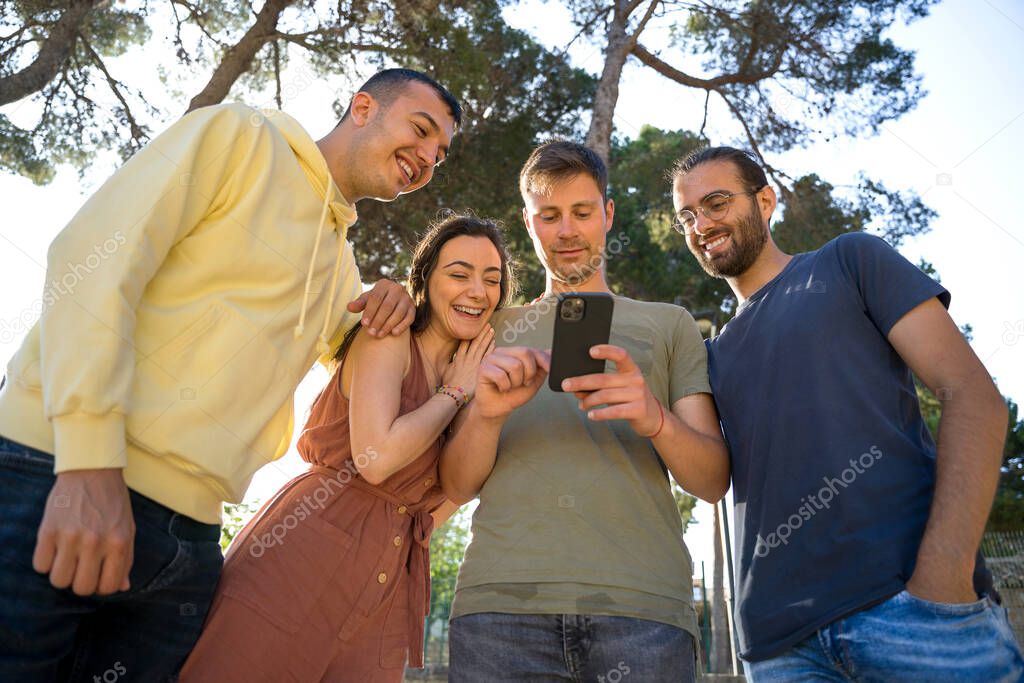 Friends smiling while looking at a mobile phone