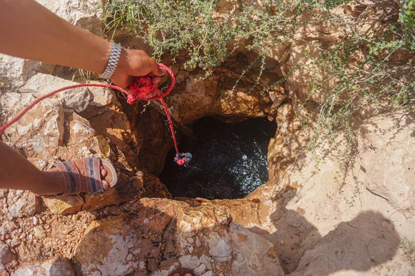 Man pulling out bucket of water from a well — Stock Image Man Pulling Out Bucket Water Well Royalty Free Stock Images
