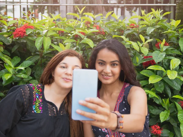 İki farklı ırktan kız arkadaşın selfie çekerken çekilmiş fotoğrafı.