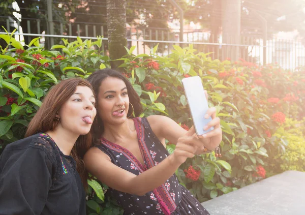 İki farklı ırktan kız arkadaşın selfie çekerken çekilmiş fotoğrafı.