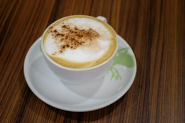 Tazza bianca contenente caffè cappuccino caldo sul tavolo — Foto Stock