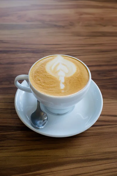 Sanat latte üzerinde ahşap masa kahve bir fincan