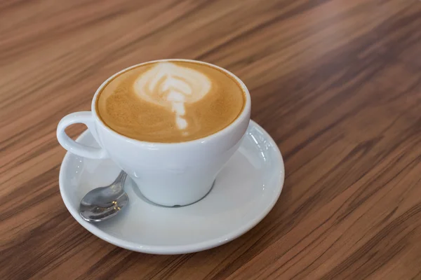 Ένα φλυτζάνι του latte art καφέ στο τραπέζι στο καφέ — Φωτογραφία Αρχείου