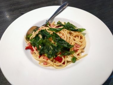 Spagetti pastırma gevrek fesleğen ile beyaz tabak içinde bırakır