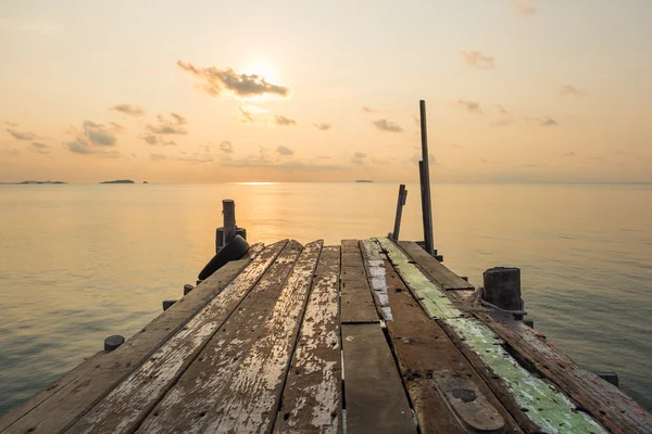 Dřevěné přístavních mol most s klidnou scénu seascape během východ slun — Stock fotografie