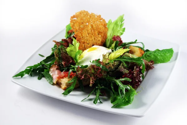 Salade met gepocheerde ei en kernachtig brood — Stockfoto