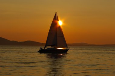 Deniz yüzeyinde yansımaları batımına yelken 