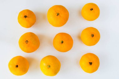 Beyaz arkaplanda geniş bir mandalina grubu, turuncu arkaplan