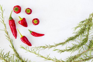 Beyaz arka planda kırmızı biber ve ham biberiye dalları