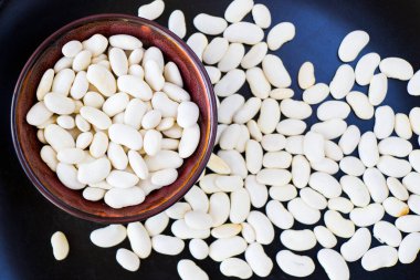 Kasede ve arka planda sağlıklı beyaz fasulyeler var.