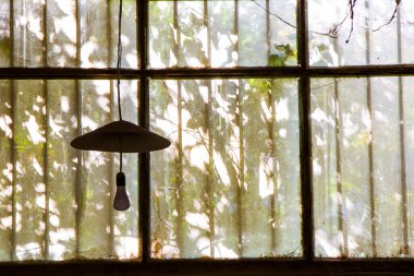 Eski binadaki eski pencereler ve fabrikadaki hafif ekipman, güneş ışığı