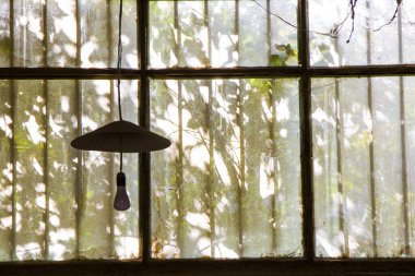 Eski binadaki eski pencereler ve fabrikadaki hafif ekipman, güneş ışığı