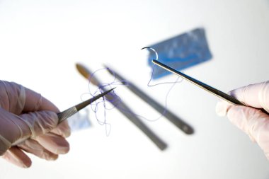 Ameliyat ekipmanları, neşter, bıçak, dikiş ve iğne beyaz arka planda. Stüdyo çekimi.