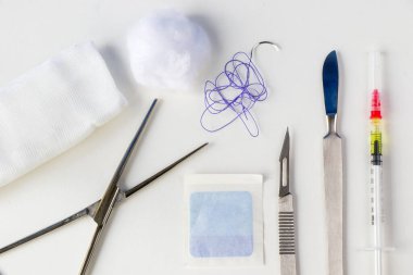 Ameliyat ekipmanları, neşter, bıçak, dikiş ve iğne beyaz arka planda. Stüdyo çekimi.