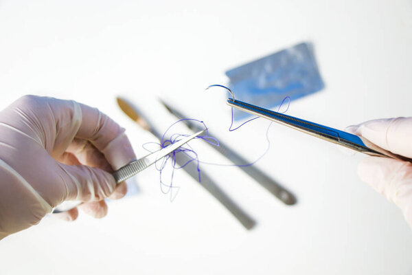 Surgery operation equipment, scalpel, knife, suture and needle on the white background. Studio shoot.