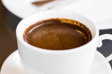 Türk fincanı pf kahve, koyu kahve yakın çekim ve makro, beyaz fincanda sıcak aromatik içecek.