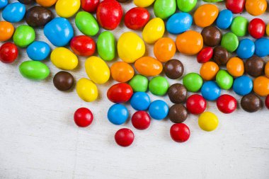 Beyaz arkaplanda M & M 'nin şekeri, renkli şeker dokusu, çok renkli gradyan.