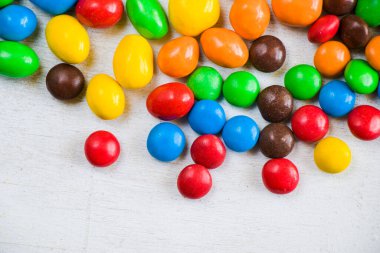 Beyaz arkaplanda M & M 'nin şekeri, renkli şeker dokusu, çok renkli gradyan.