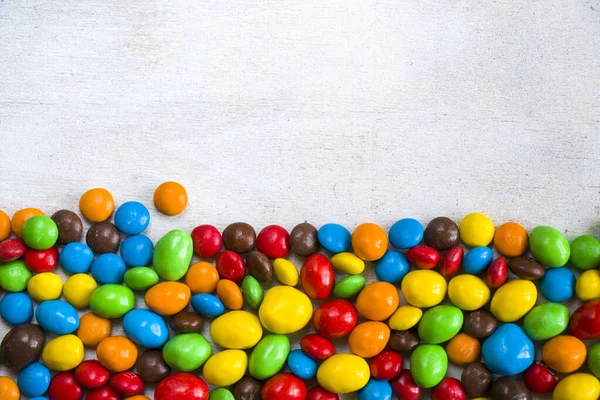 Beyaz arkaplanda M & M 'nin şekeri, renkli şeker dokusu, çok renkli gradyan.
