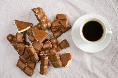 Beyaz arka planda bir fincan siyah espresso kahve ve çikolata, sabah kahve saati.